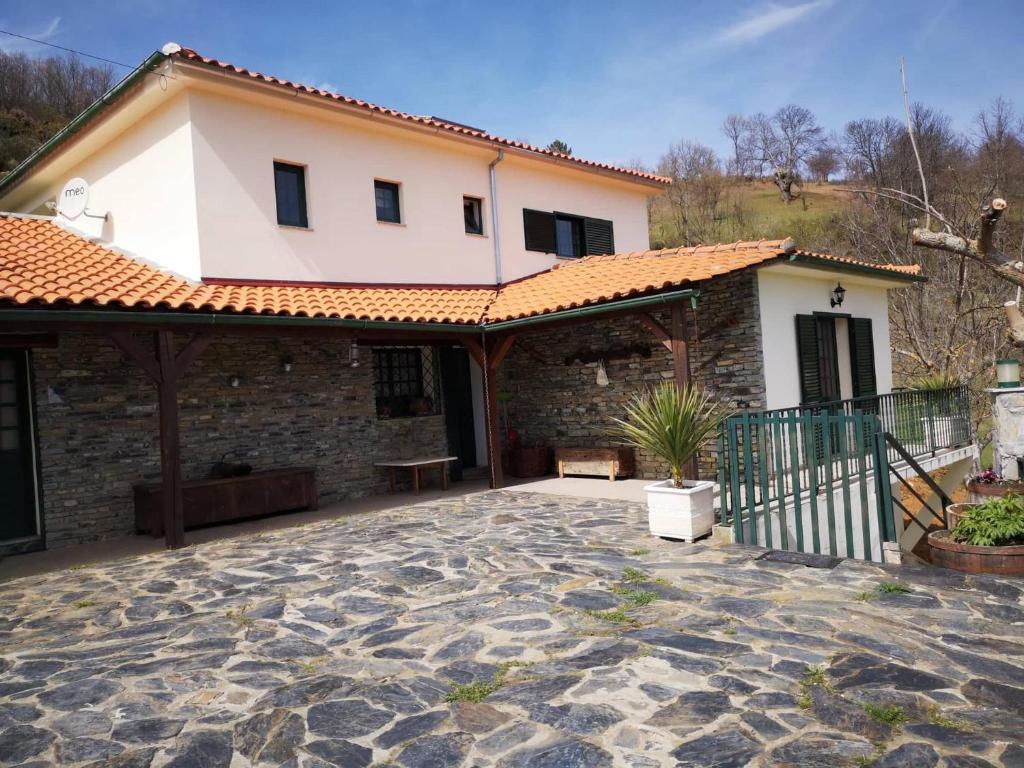 una casa con un patio de piedra frente a ella en Alojamento Local Madre de Cima, en Vinhais