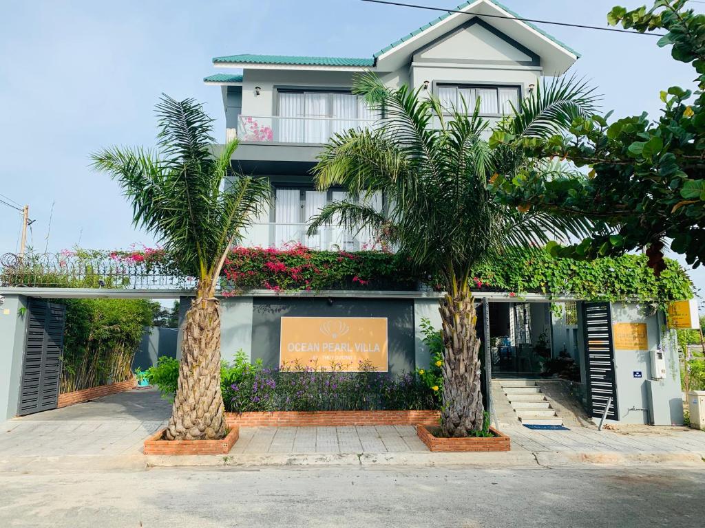 two palm trees in front of a building at Ocean Pearl Villa in Vung Tau