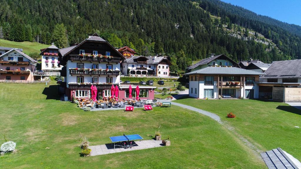an aerial view of a large building on a grass field at See Hotel Kärntnerhof- das Seehotel am Weissensee! in Weissensee