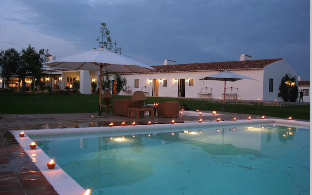 a swimming pool in front of a house at night at Monte da Boavista - Country family house in Alter do Chão