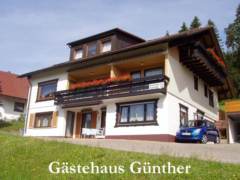 een huis met een blauwe auto die ervoor geparkeerd staat bij Ferienwohnung Günther in Baiersbronn