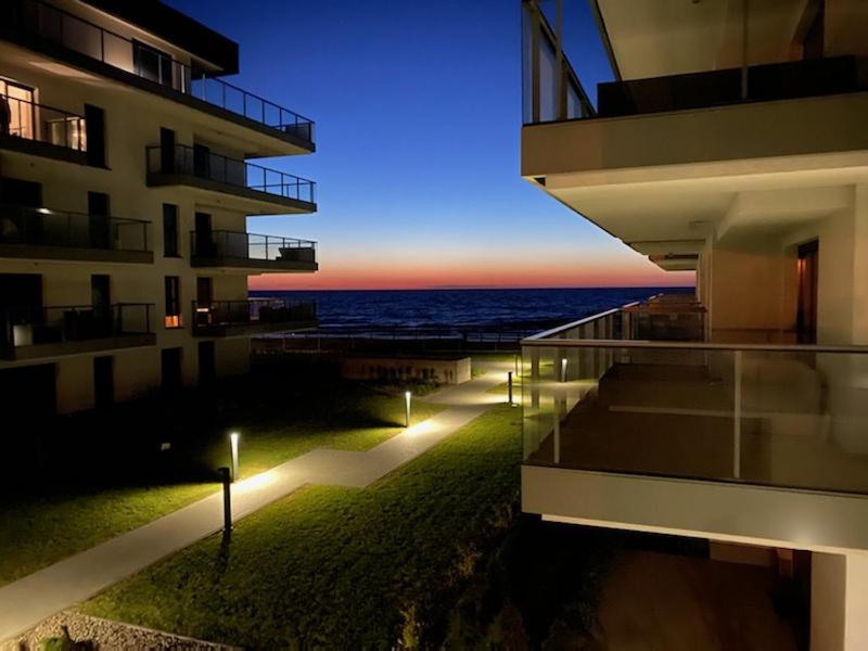 a building with a view of the ocean at night at Apartament IDEAL in Dziwnów