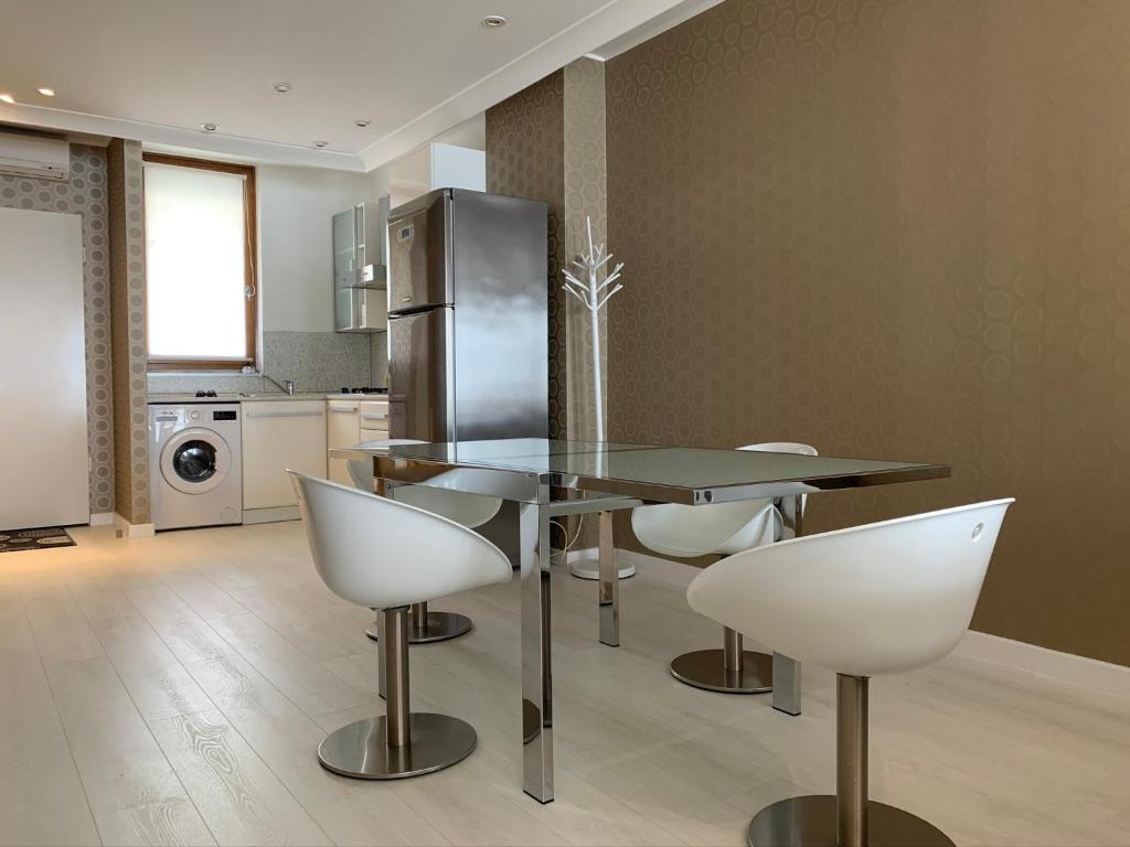 a kitchen with a table and chairs and a refrigerator at Ruben Apartman City Center in Debrecen