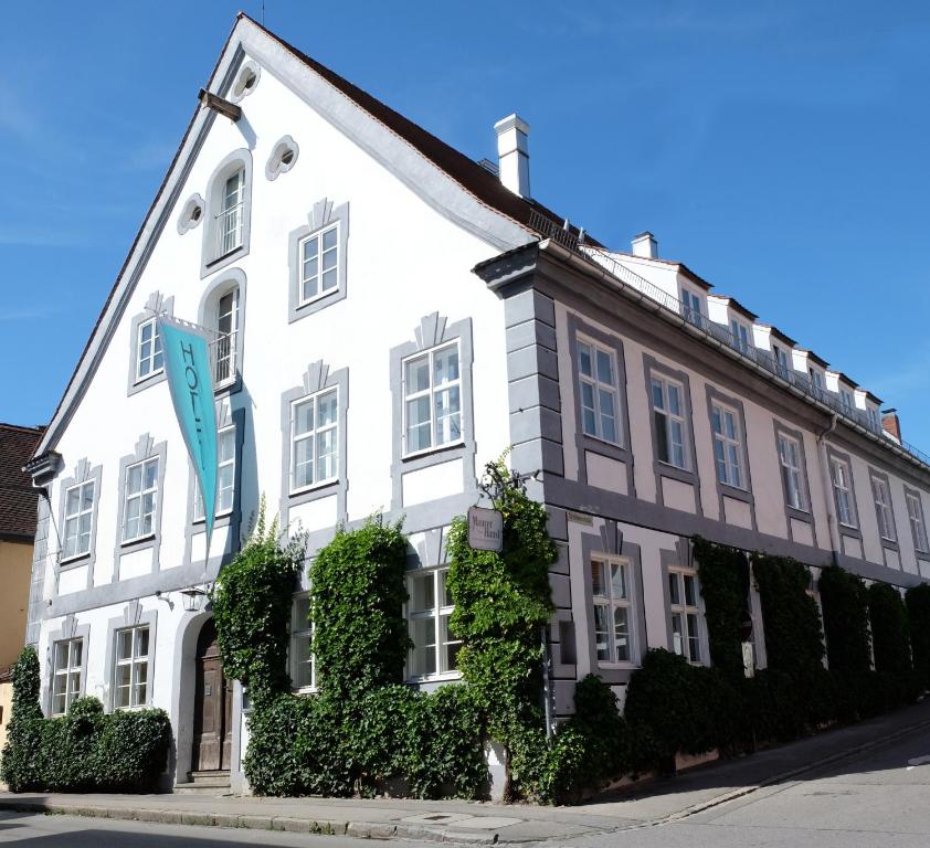 un edificio blanco con hiedra creciendo en él en Hotel Maurerhansl en Dießen am Ammersee