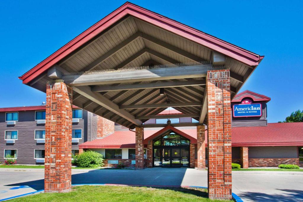 un bâtiment avec un auvent en face d'un hôtel dans l'établissement AmericInn by Wyndham Grand Forks, à Grand Forks