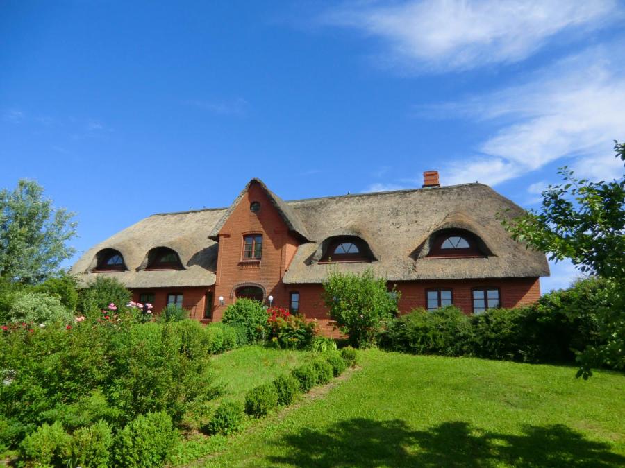 a house with a thatched roof on a hill at Hollandwarft in Pellworm