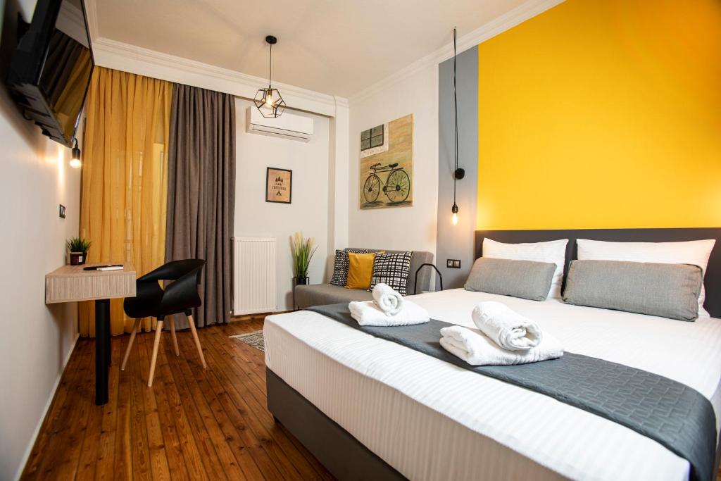 een slaapkamer met een groot bed en een gele muur bij Thess Quality Urban Living in Thessaloniki