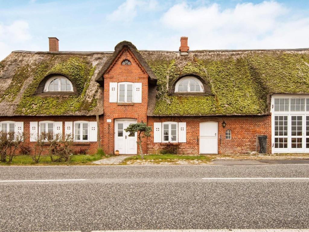 een oud stenen huis met klimop op het dak bij Holiday home Højer VIII in Højer