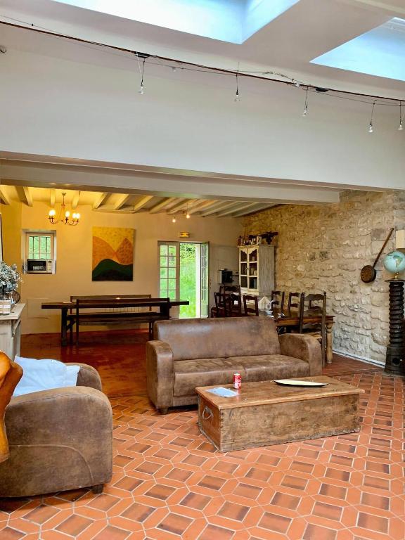 - un salon avec des canapés et un mur en briques dans l'établissement Chambres au Domaine de Seraincourt, à Seraincourt