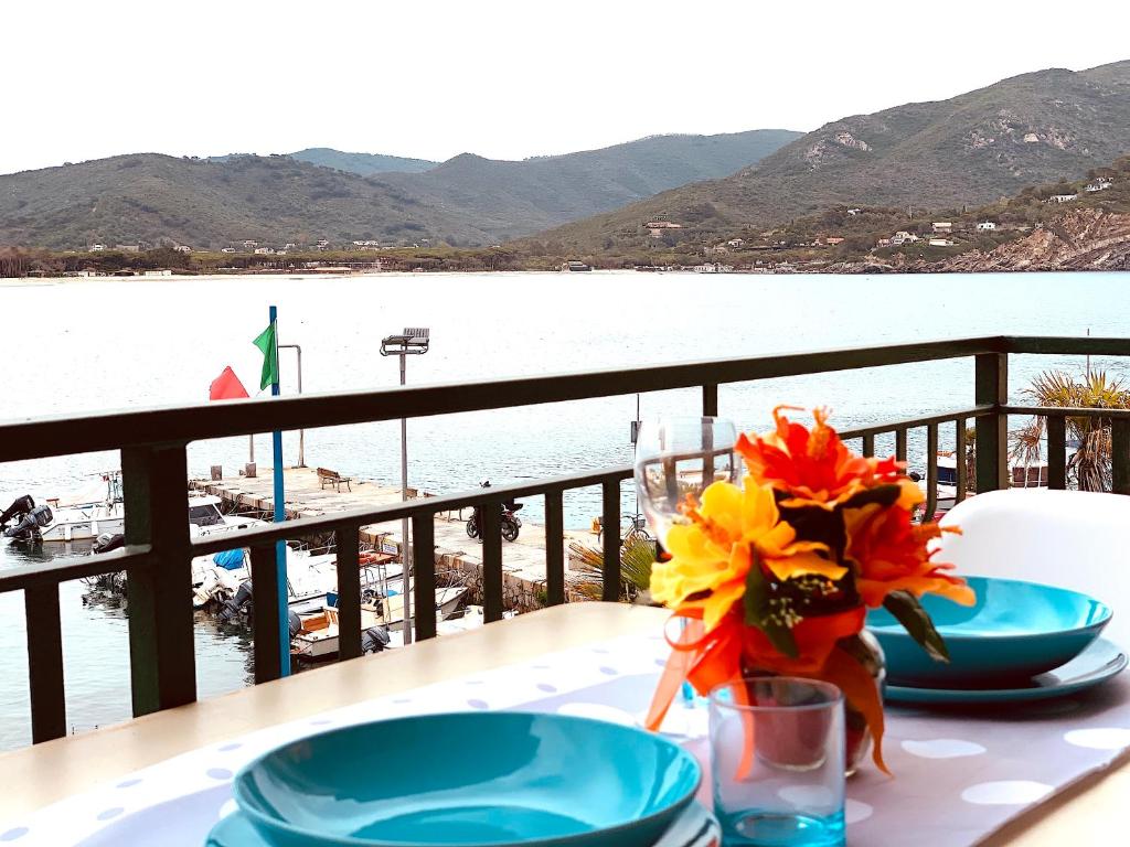 a table with two plates and a vase with flowers on it at La Casa di Mia in Marina di Campo