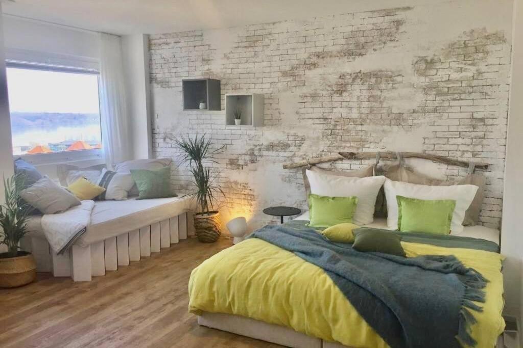 ein Schlafzimmer mit einem Bett und einer Ziegelwand in der Unterkunft Liebevoll renoviertes Apartment mit Panoramablick in Friedrichshafen