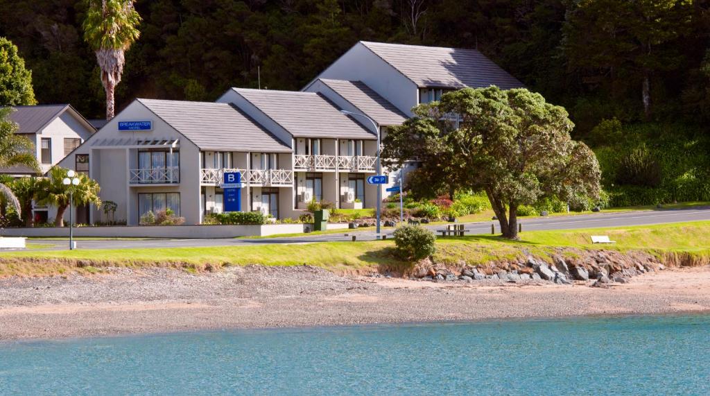 a house on the side of a road next to the water at Breakwater Motel in Paihia