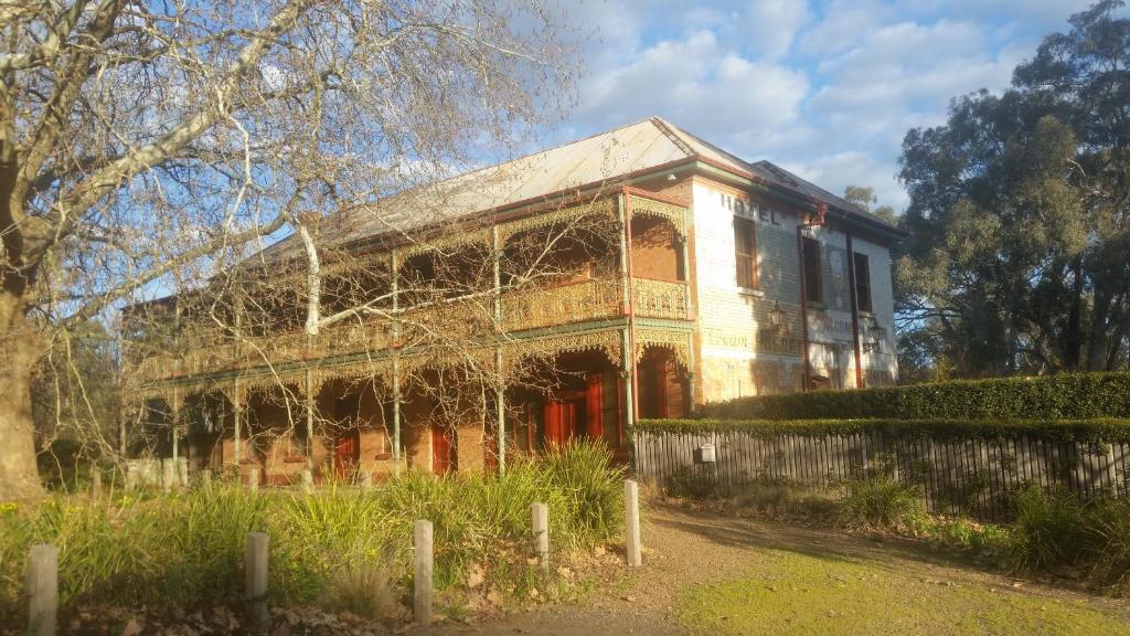 an old house with red doors and a fence at Thornebridge in Murchison