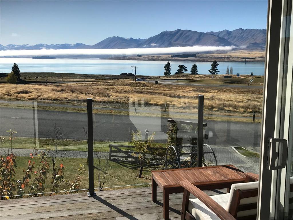 a balcony with a table and a view of a lake at The Mackenzie Suites in Lake Tekapo
