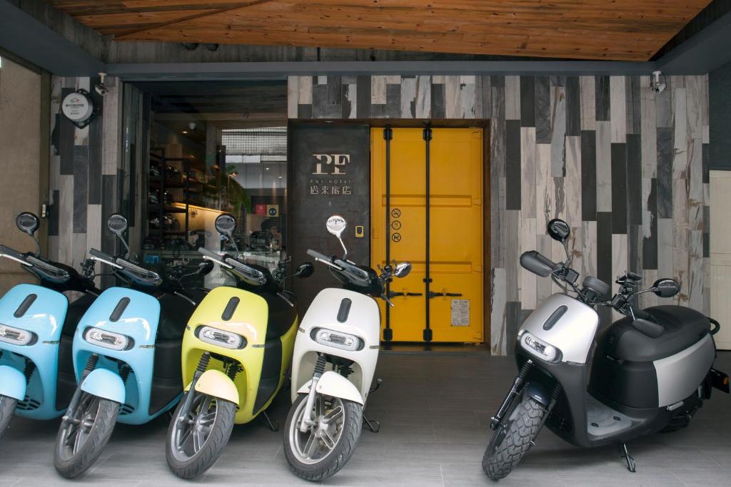 a row of scooters parked in front of a garage at P&amp;F Hotel in Taichung