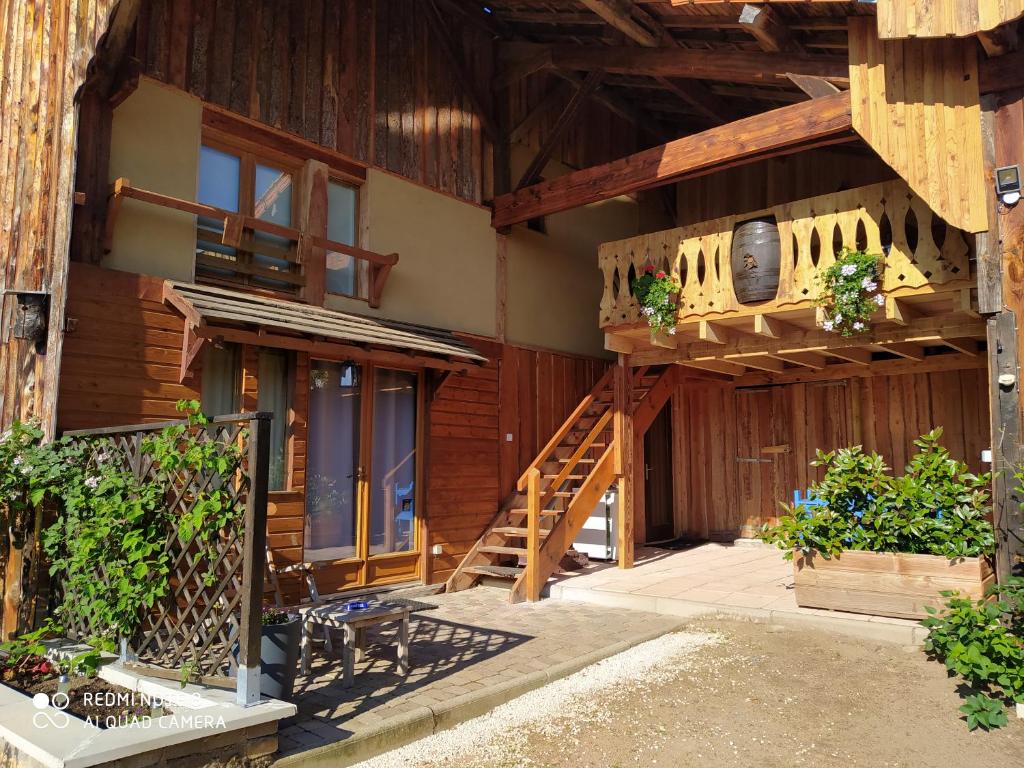 a wooden house with a staircase and a balcony at La Posada in Ambierle