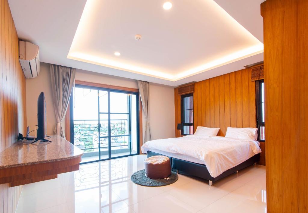 een slaapkamer met een bed en een televisie. bij U-Home Private 80-86sqm adjustable 2bedrooms Wooden Decor 80平米 in Chiang Mai