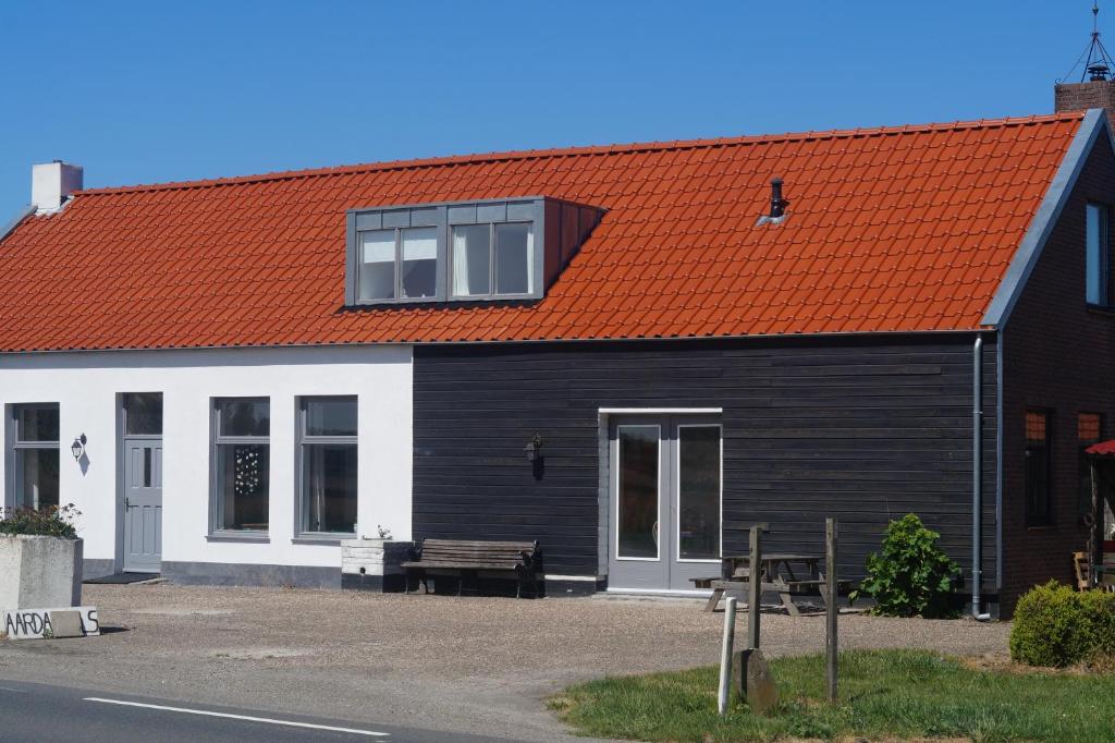 un edificio bianco e nero con tetto arancione di Vakantiewoning Het Olietunnetje a Ovezande