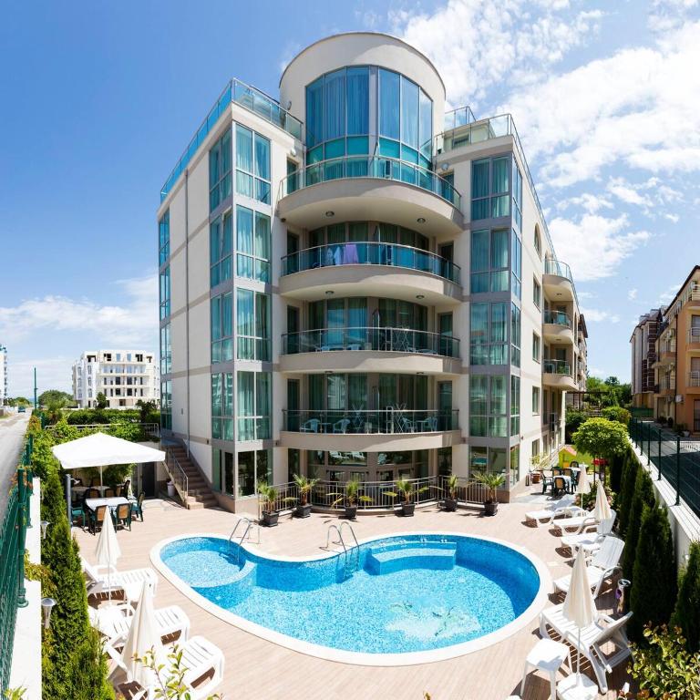 a hotel with a swimming pool and a building at Zevs Residence in Nesebar