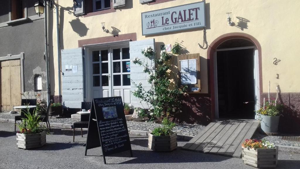 a restaurant with a sign in front of a building at Le Galet "Chez Jacquie et Fifi" in Mont-Dauphin