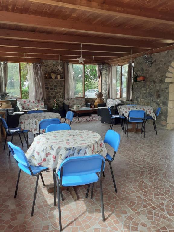 a room with tables and blue chairs in a building at agriturismo heaven in Capo Vaticano