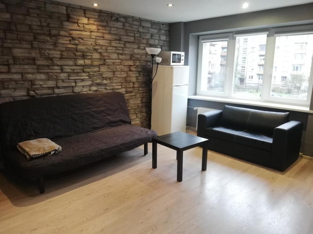 ein Wohnzimmer mit einem Sofa und einem Stuhl in der Unterkunft Quiet studio apartment in the city center of Klaipeda in Klaipėda