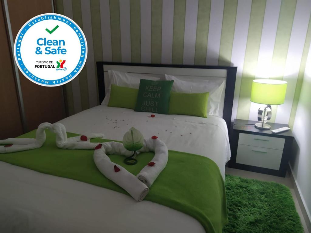 1 dormitorio con 1 cama con un cartel verde y seguro en Casa da Liberdade em Nazaré, en Nazaré