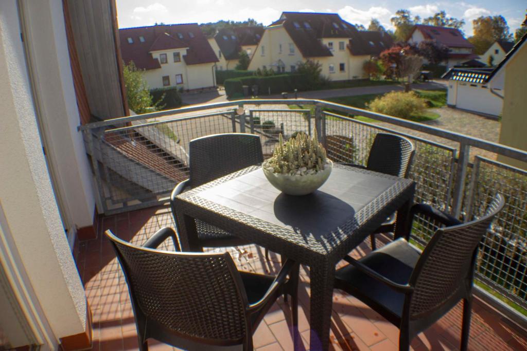 een tafel en stoelen op een balkon met uitzicht bij Ferienwohnung Ostseefeeling 3 LINW in Ostseebad Karlshagen