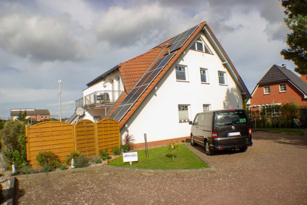 a van parked in front of a white house at Ferienwohnung Ostseefeeling 4 in Ostseebad Karlshagen