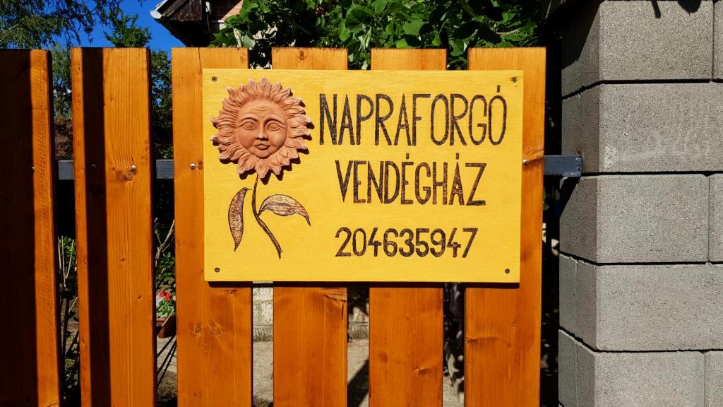 un cartel en una valla de madera con un cartel en ella en Napraforgó Vendégház, en Gárdony