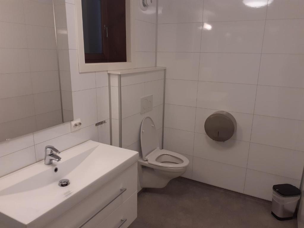 a white bathroom with a toilet and a sink at Skudenes Camping in Skudeneshavn