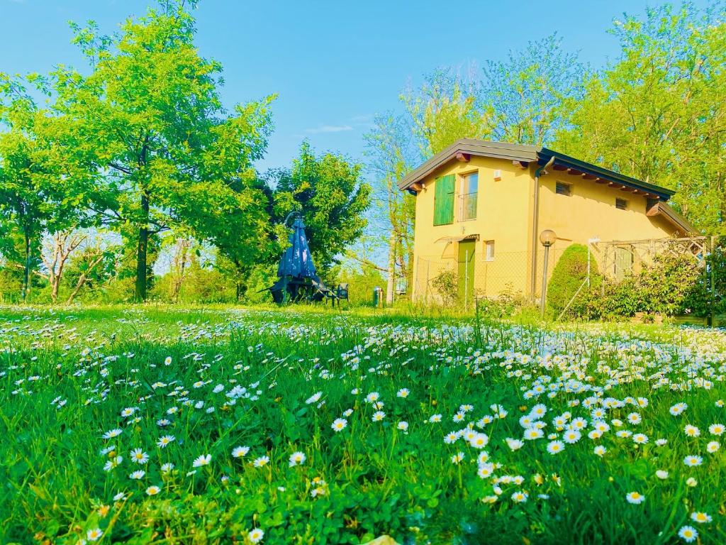 a house with a statue in a field of flowers at B&B Nido Sui Laghi in San Donnino della Nizzola