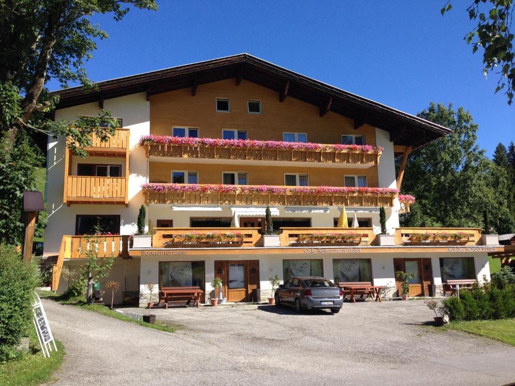 um grande edifício com um carro estacionado em frente em Sonnleiten - Guggerhof - Villa Sonnenwies em Tannheim