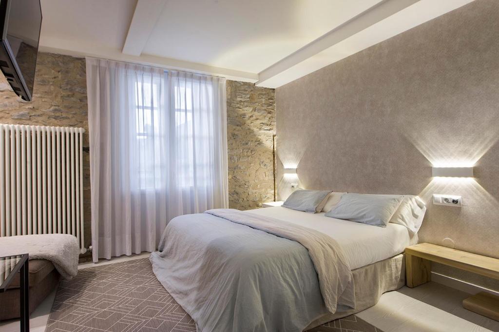 a bedroom with a large bed and a window at La Casa de Los Arquillos in Vitoria-Gasteiz