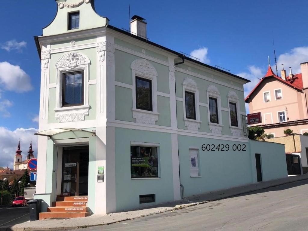 un edificio blanco con una torre de reloj en una calle en JP-KU ubytování Kadaň en Kadaň