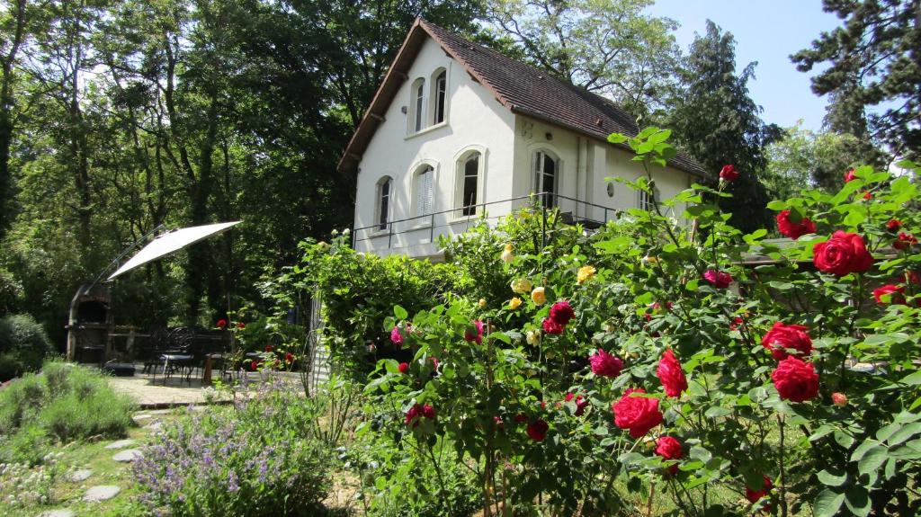 ein altes Haus mit Rosen im Garten in der Unterkunft LA CHERIELLE in Auvers-sur-Oise