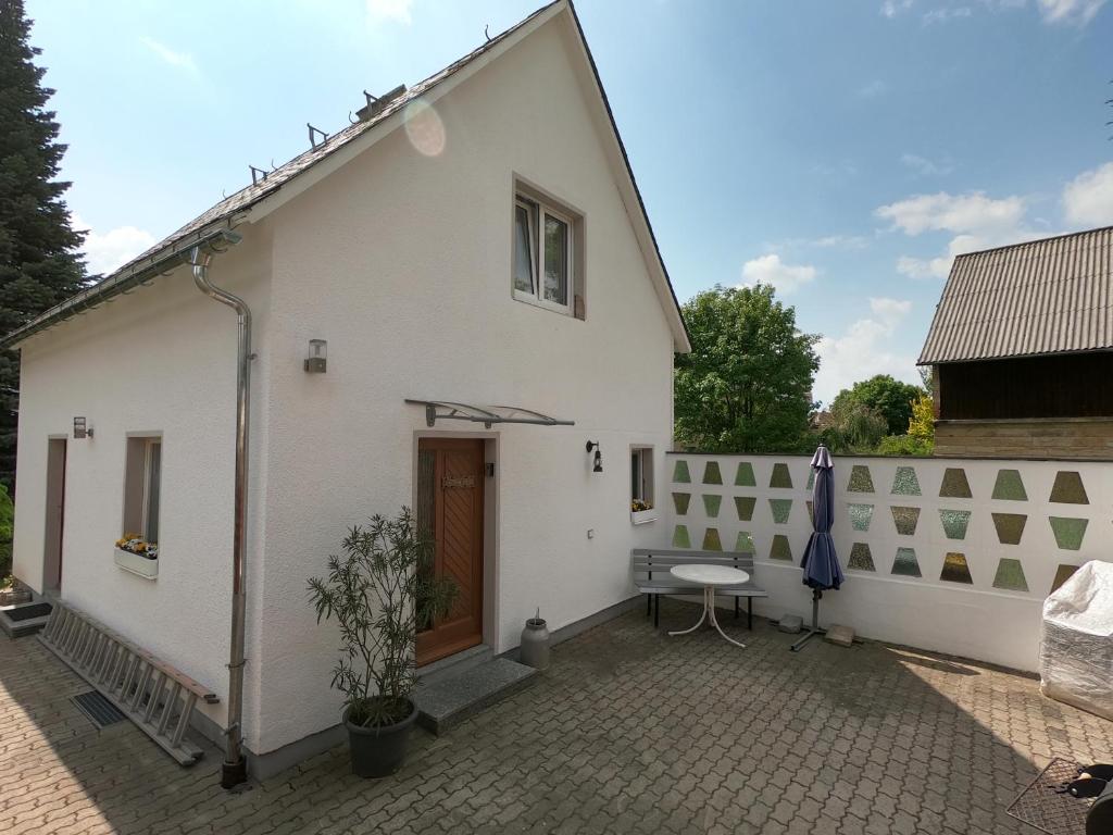 ein weißes Haus mit einem Tisch und einem Zaun in der Unterkunft "Onkel Tom's Hütte" in Altendorf