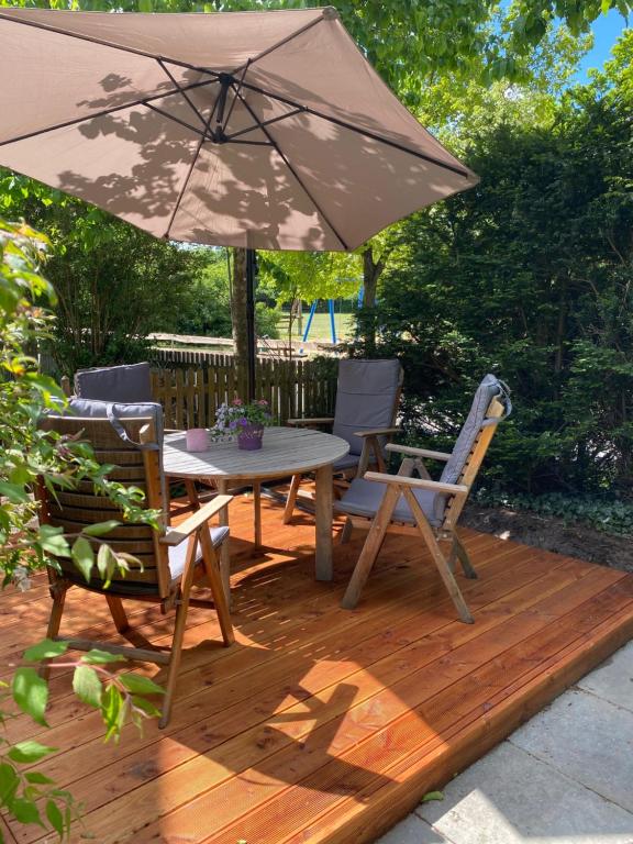 a patio with a table and chairs and an umbrella at FeWo Nelly Marie Wohnung Nelly in Hademstorf