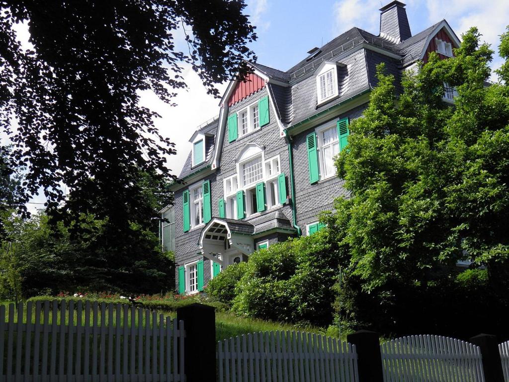 a large colorful house with a fence in front of it at Villa Erbschloe in Remscheid