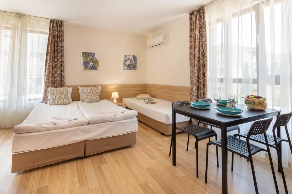 Un dormitorio con una cama y una mesa con sillas. en Apartments Flora 1, en Burgas