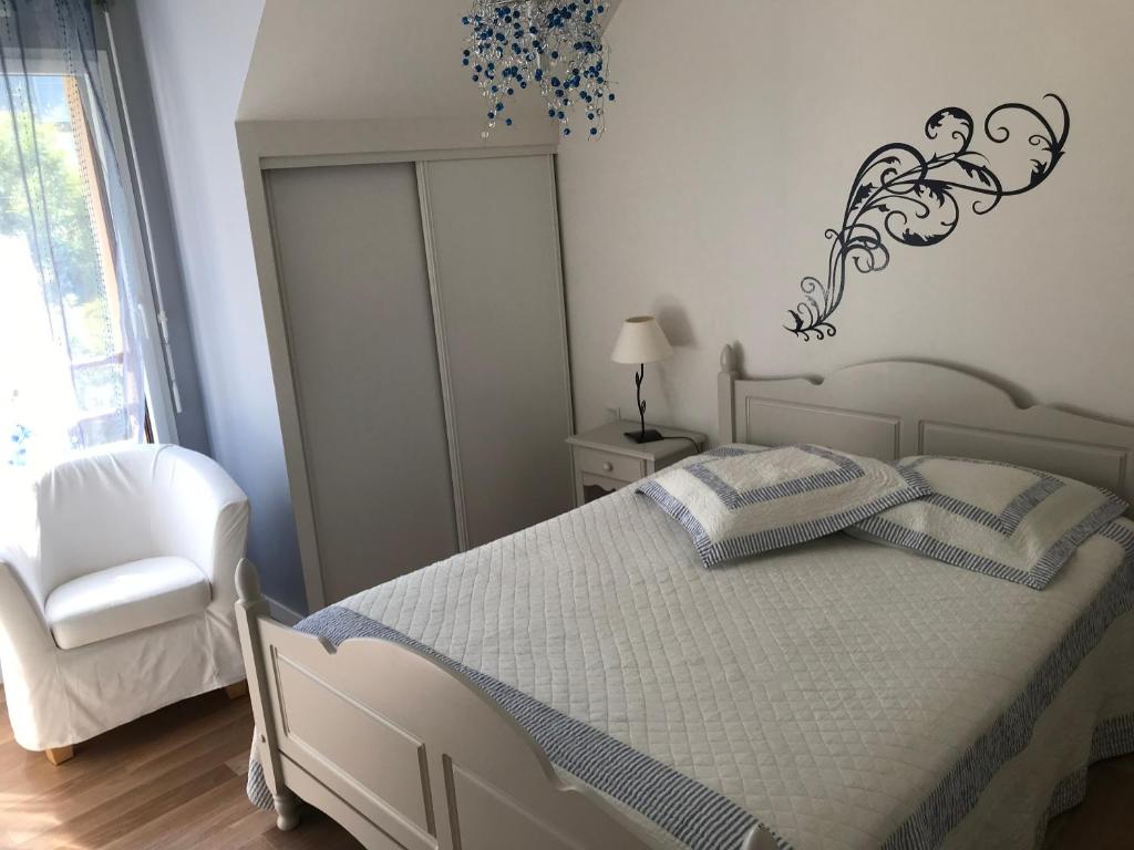 - une chambre avec un lit blanc et une chaise blanche dans l'établissement Ker Marine, à Baden