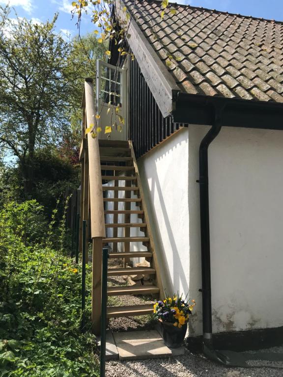 una escalera que conduce a una casa con techo en Rum på landet, en Klagstorp