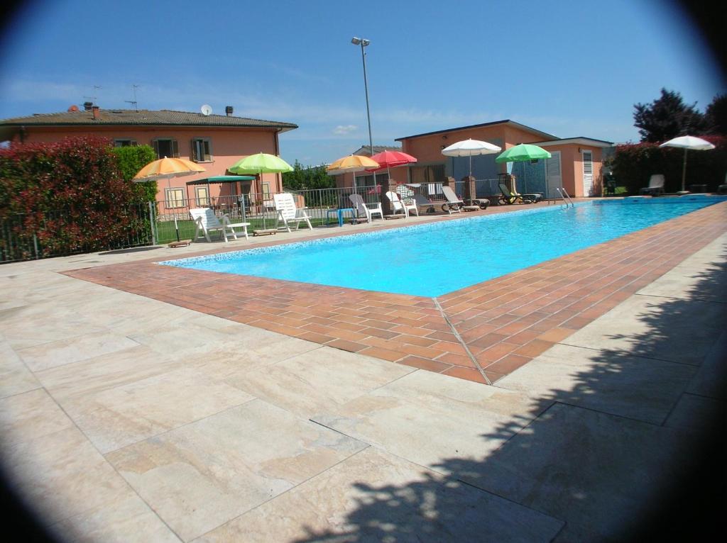 einen Pool mit Tischen, Stühlen und Sonnenschirmen in der Unterkunft VILLA MARIA in Altopascio