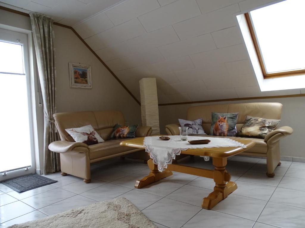 a living room with two couches and a table at Ferienwohnung Hasetal in Herzlake