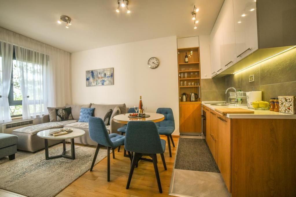 eine Küche und ein Wohnzimmer mit einem Sofa und einem Tisch in der Unterkunft Apartman Silver Lux in Zlatibor