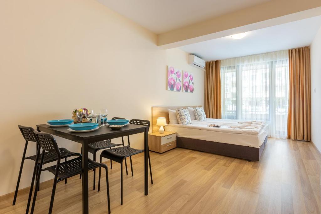 a living room with a dining table and a bed at Apartments Flora in Burgas City