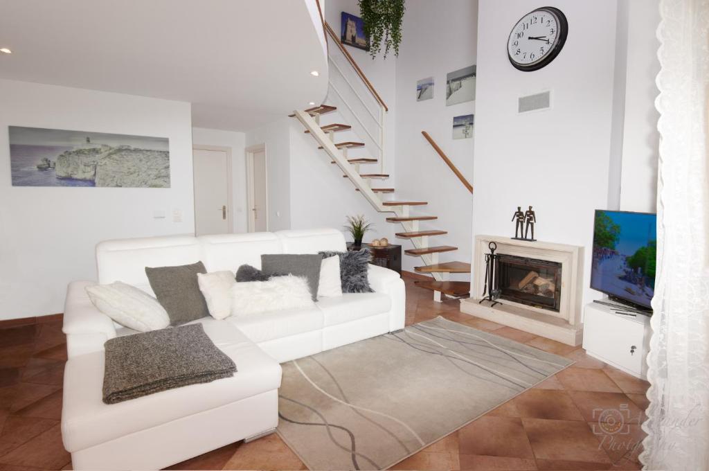 Sala de estar blanca con sofá blanco y chimenea en Exclusive Apartments Lisbon - Charneca de Caparica en Charneca