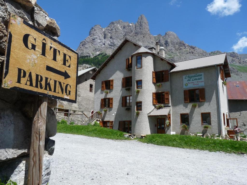 un cartel que lee la puerta de estacionamiento en frente de un edificio en Gite l'Aiguillette du Lauzet en Le Monêtier-les-Bains