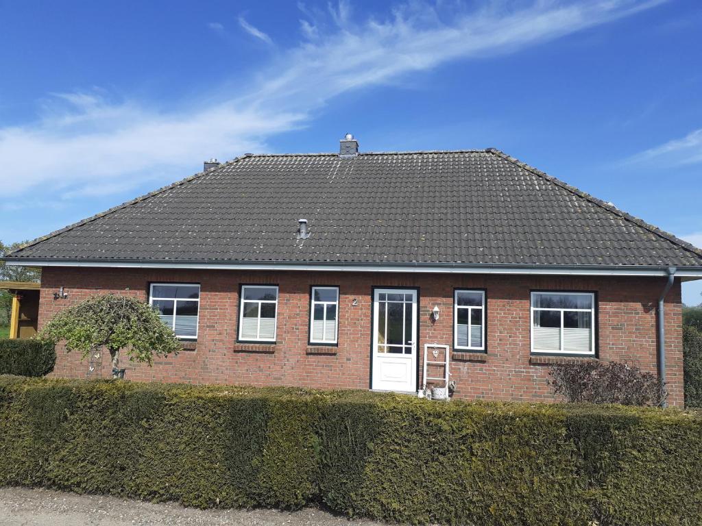 a red brick house with a black roof at Villapampa in Lürschau