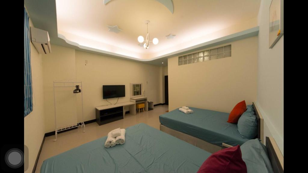a hospital room with two beds and a television at Kenting Orange Homestay in Hengchun